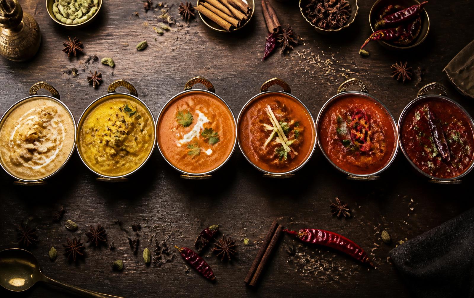 A row of Indian curries from mild korma to fiery vindaloo with whole spices