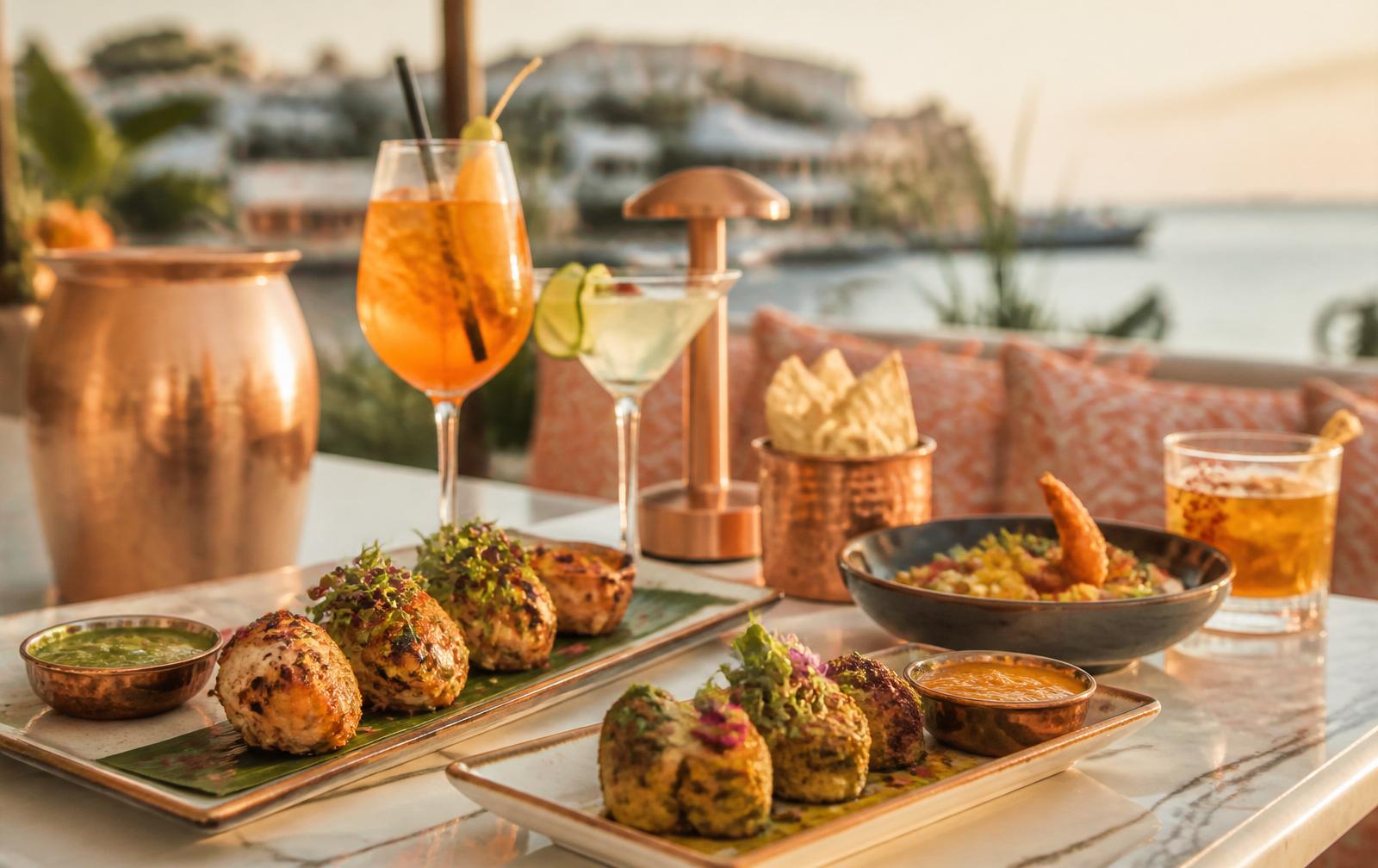 Modern Indian sharing plates and cocktails on a coastal terrace at golden hour
